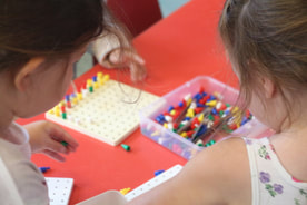 Two girls playing and learning Maths with colourful blocks