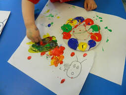 A child colouring a caterpillar in class